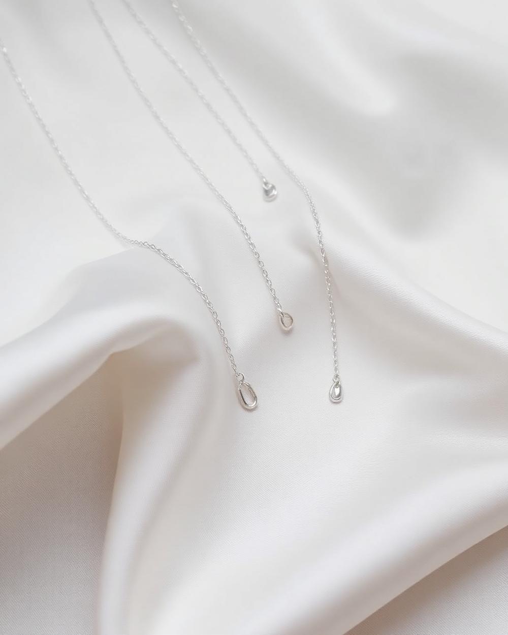 Fine silver chains resting on silk