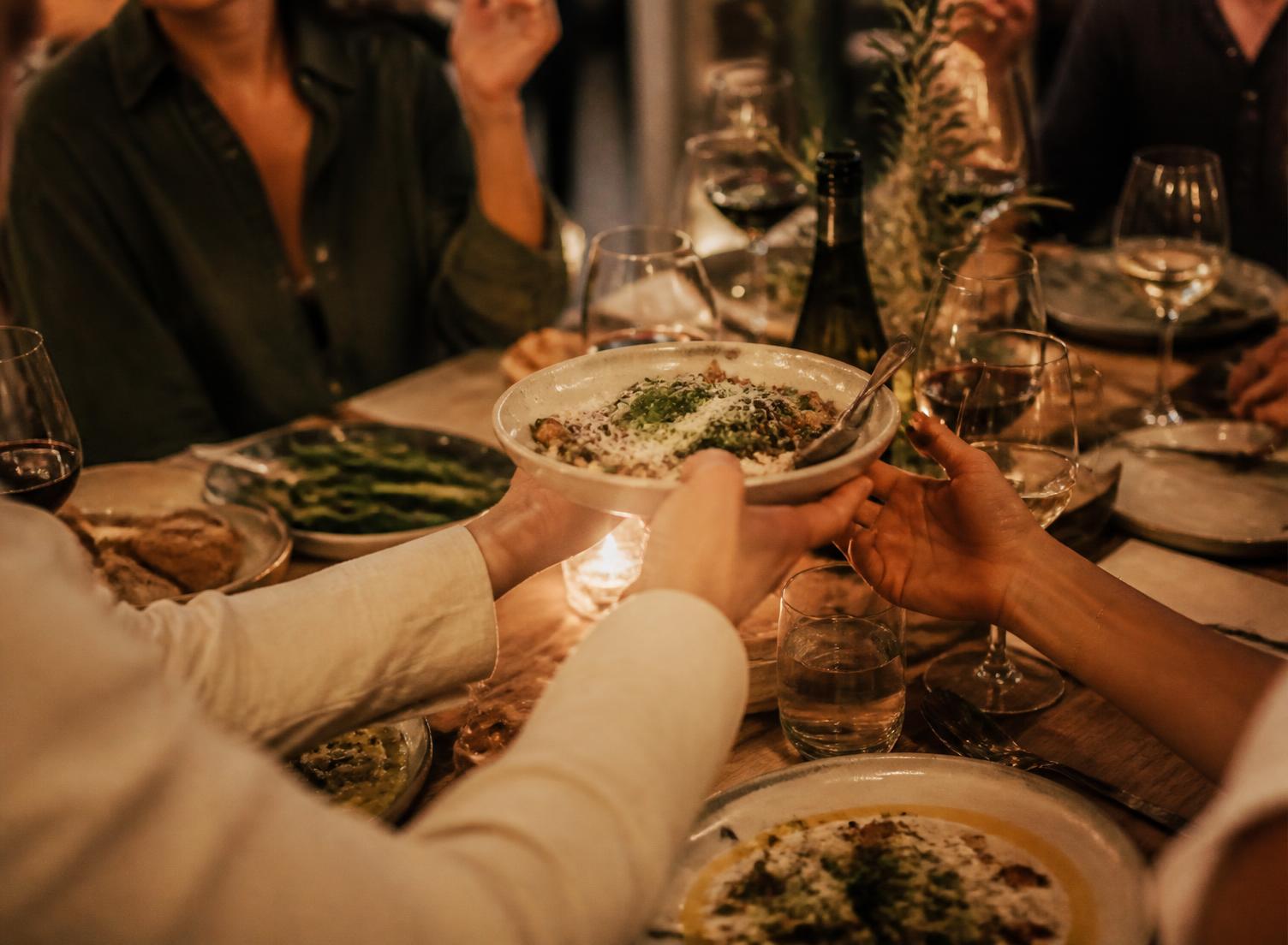 Friends sharing plates at a wooden table