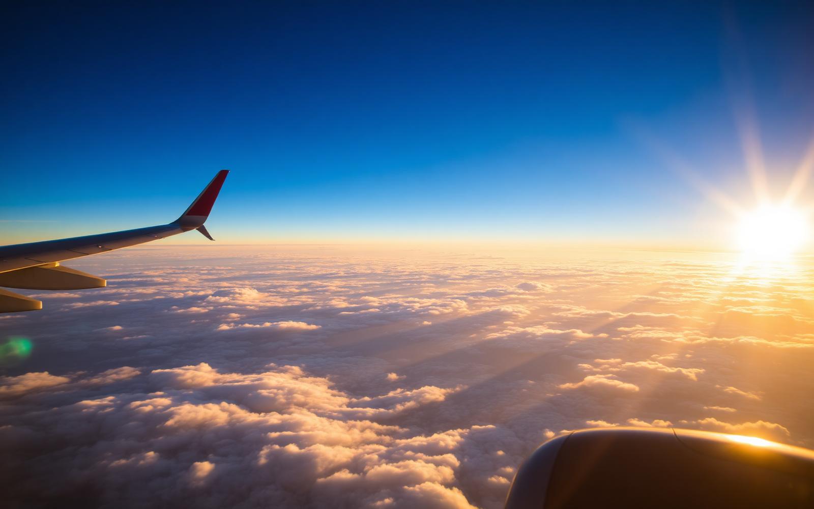 Passenger aircraft climbing above the clouds at sunrise